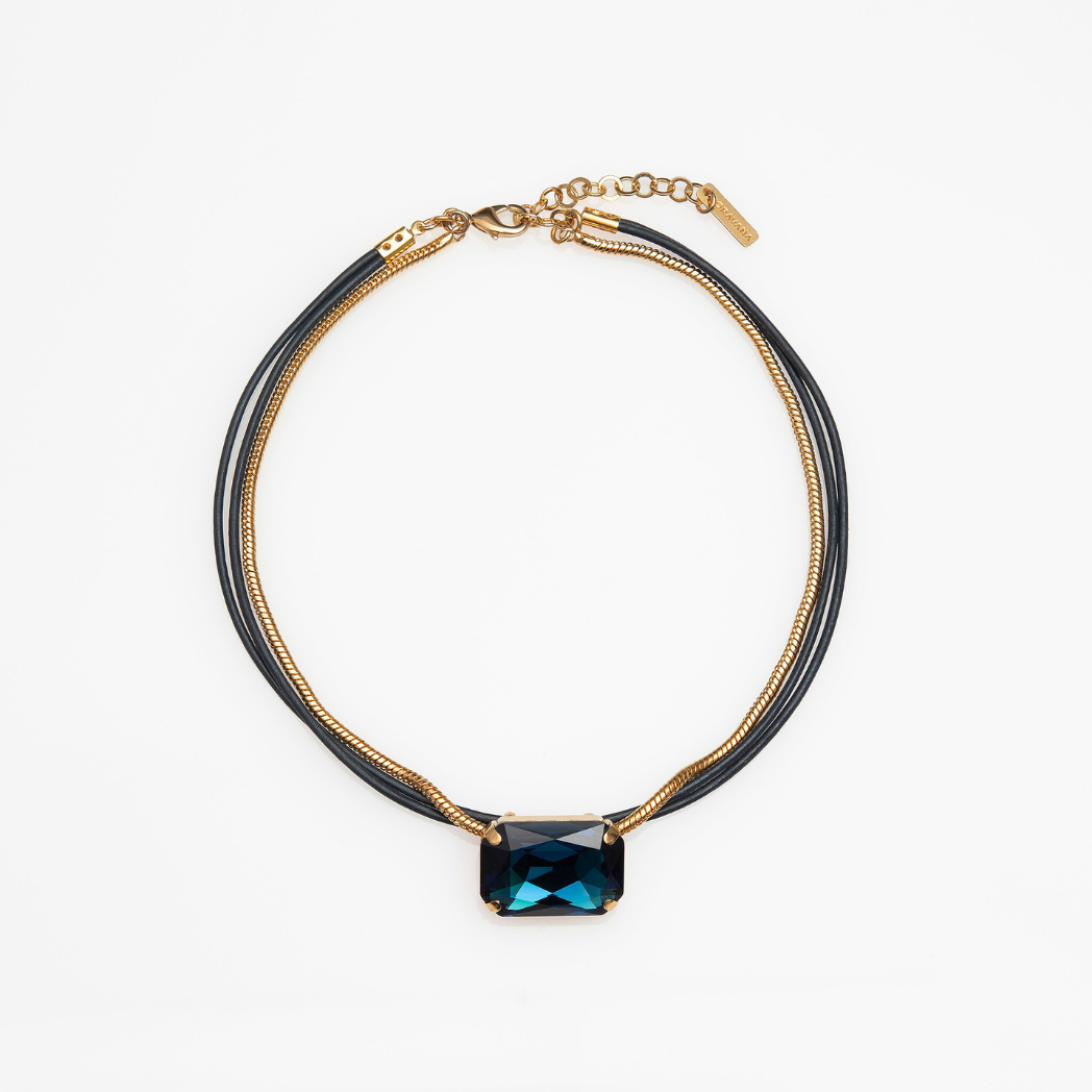 A choker necklace with a gold chain and silver leather layers, featuring an octagon-shaped pink crystal centerpiece.
