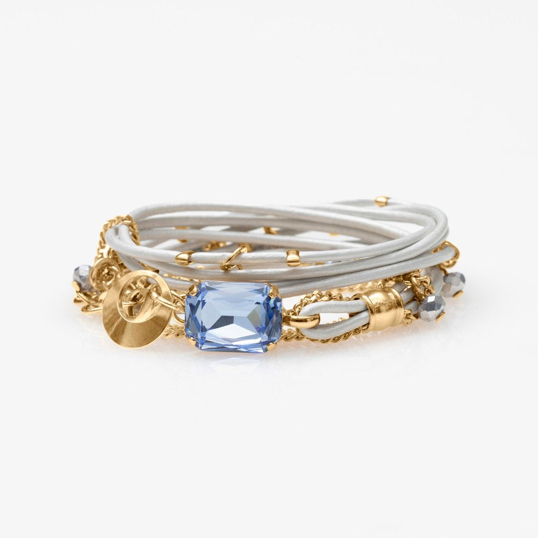 The Mini Stardust Set, a sparkling crystal leather cuff and matching stud earrings, on a light gray background.