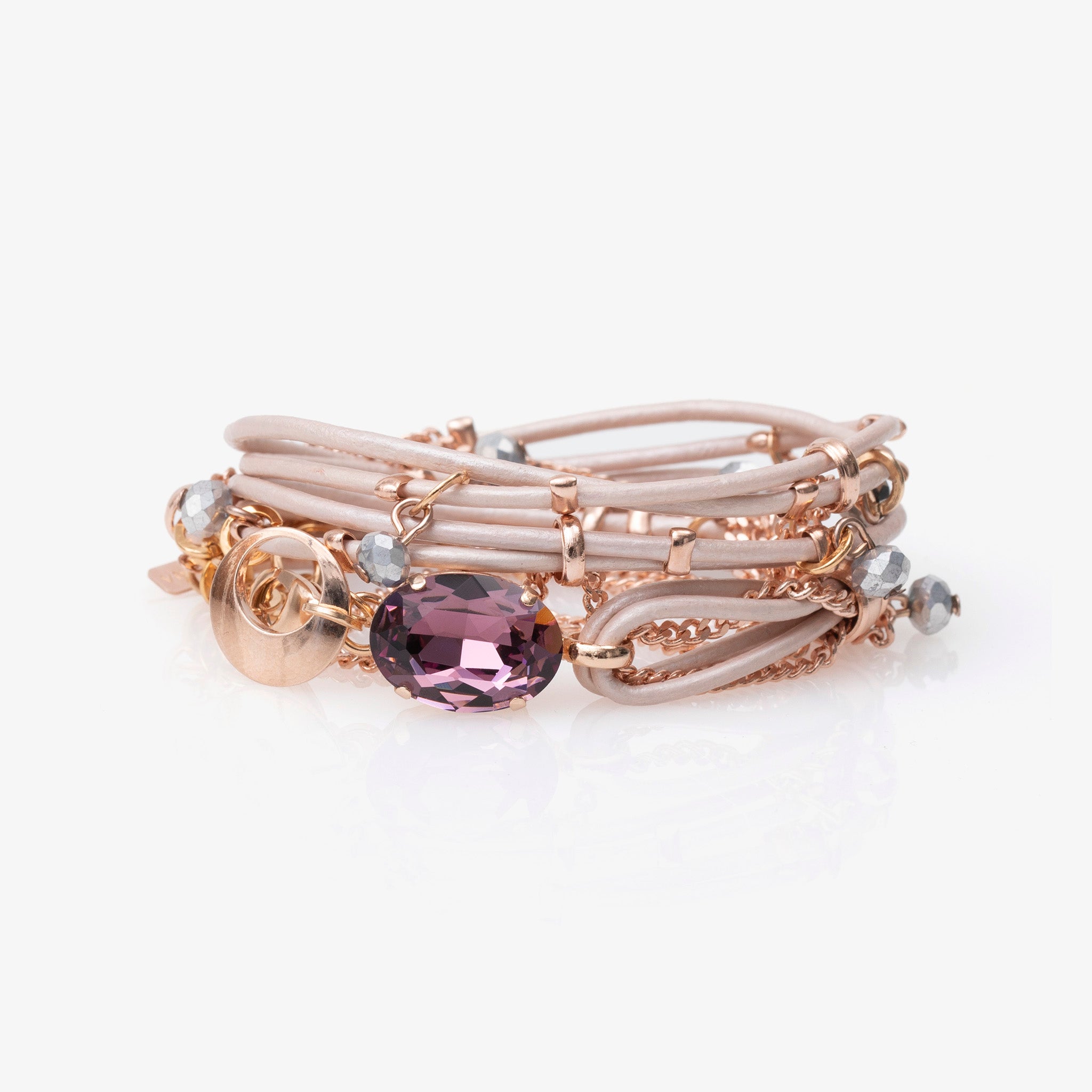 A pink Stargaze bracelet with an oval-shaped crystal centerpiece and small glass beads, featuring a gold-tone chain.