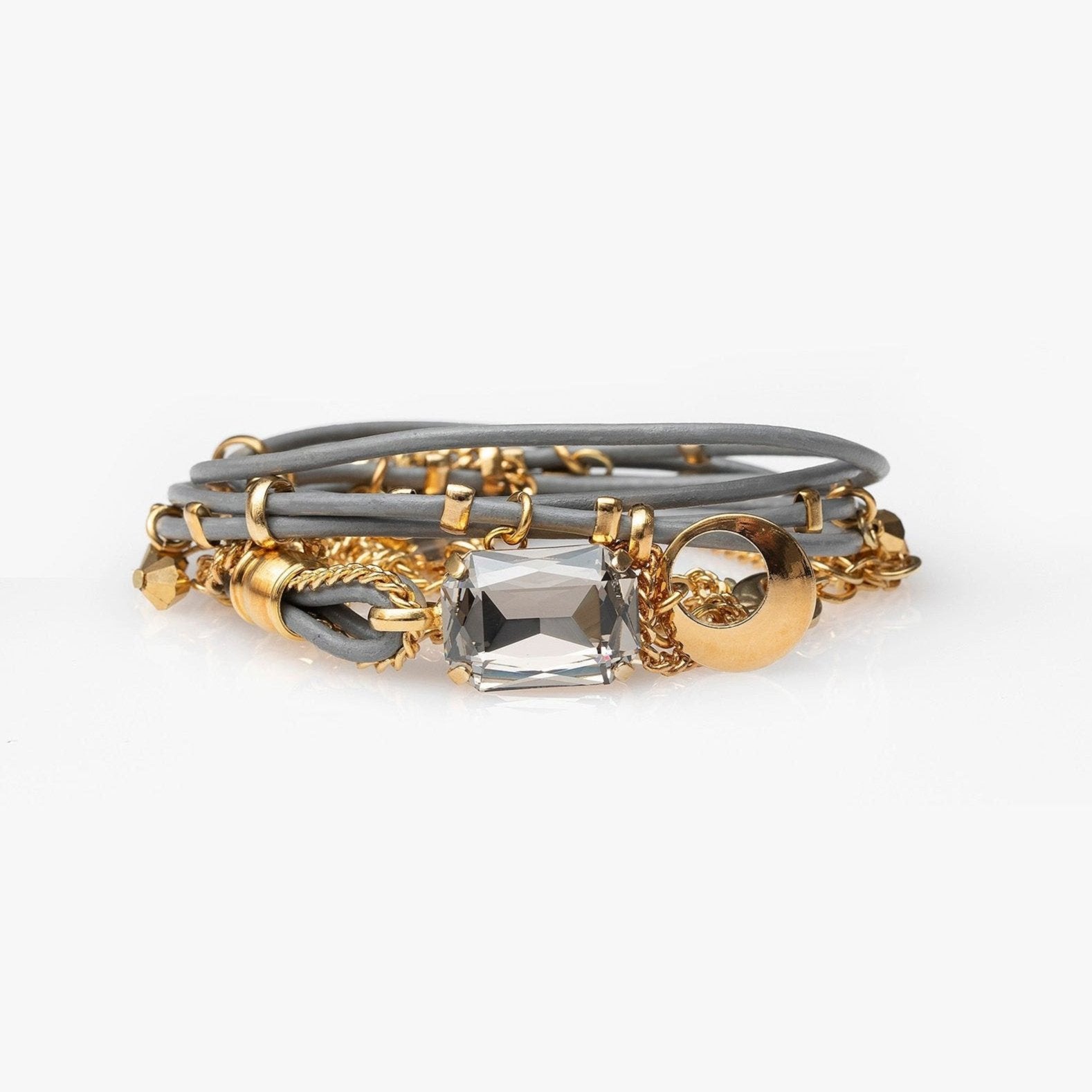The Mini Stardust Set, a handcrafted crystal-embellished leather bracelet with gold-tone sparkle studs, shown on a light gray background.