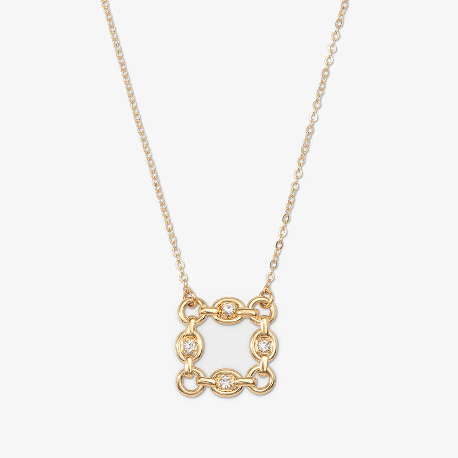Gold necklace with a square pendant on a light beige background