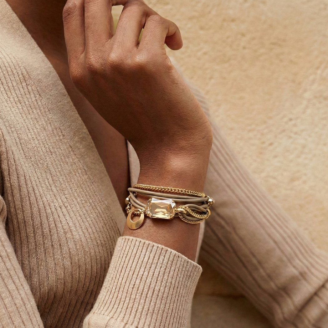 The Mini Stardust Set, a crystal-covered leather bracelet paired with sparkling stud earrings, on a light gray background.