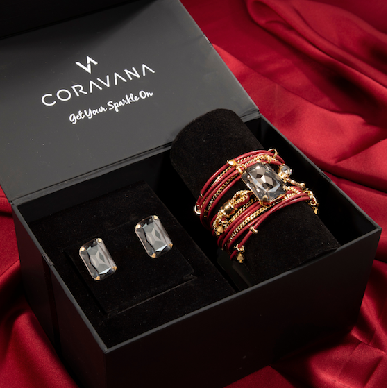Jewelry set including rings and cufflinks in a Coravana box on a red fabric background