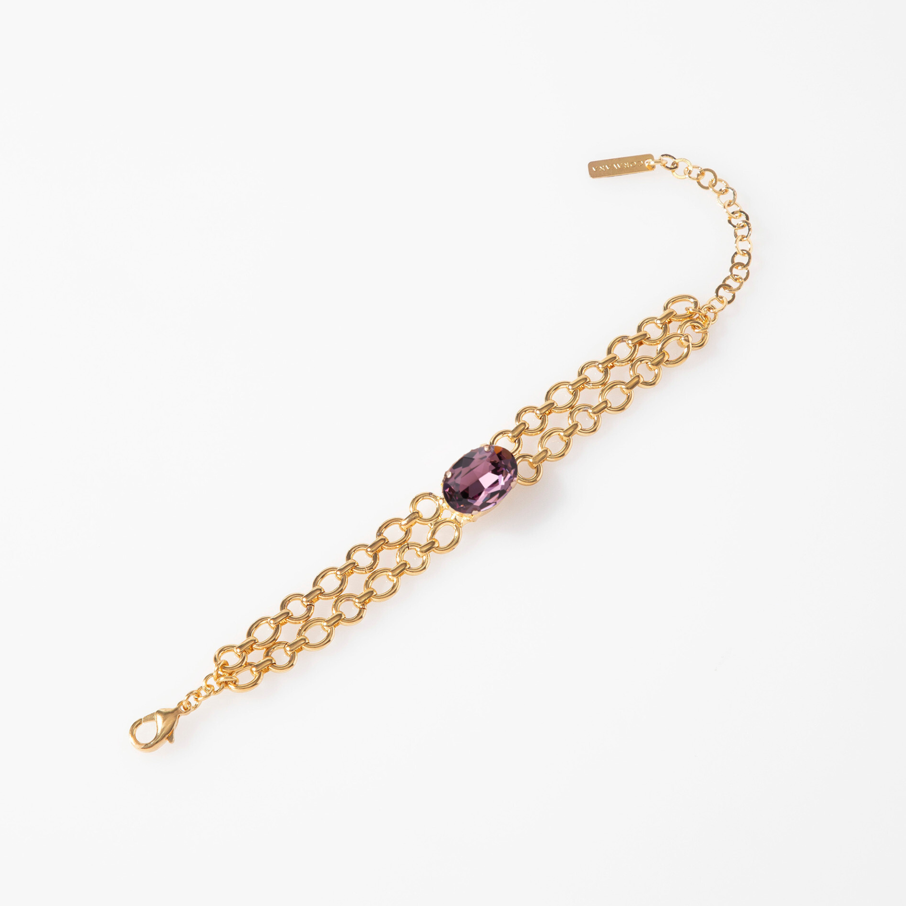 Gold chain bracelet with a purple gemstone on a white background