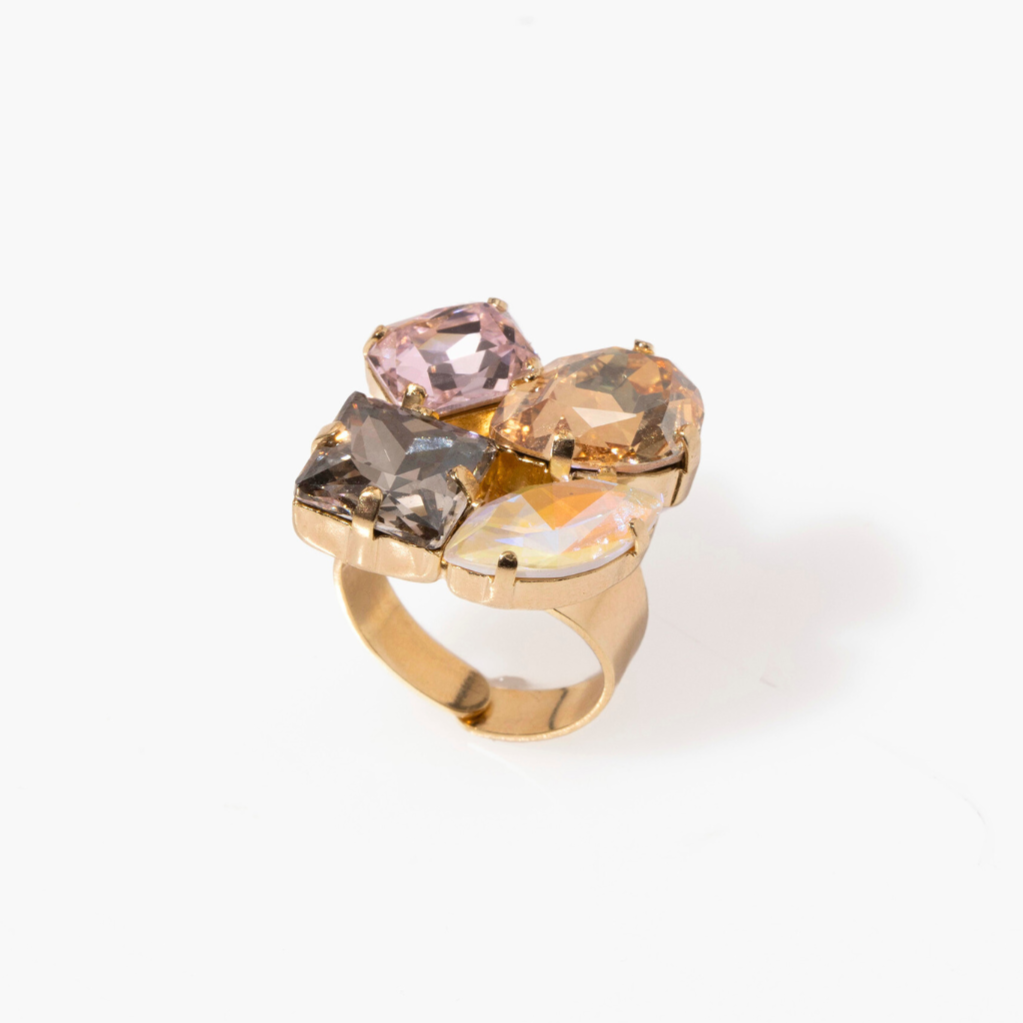 A gold-colored ring with multiple mixed-shaped pink and clear crystals as the centerpiece.