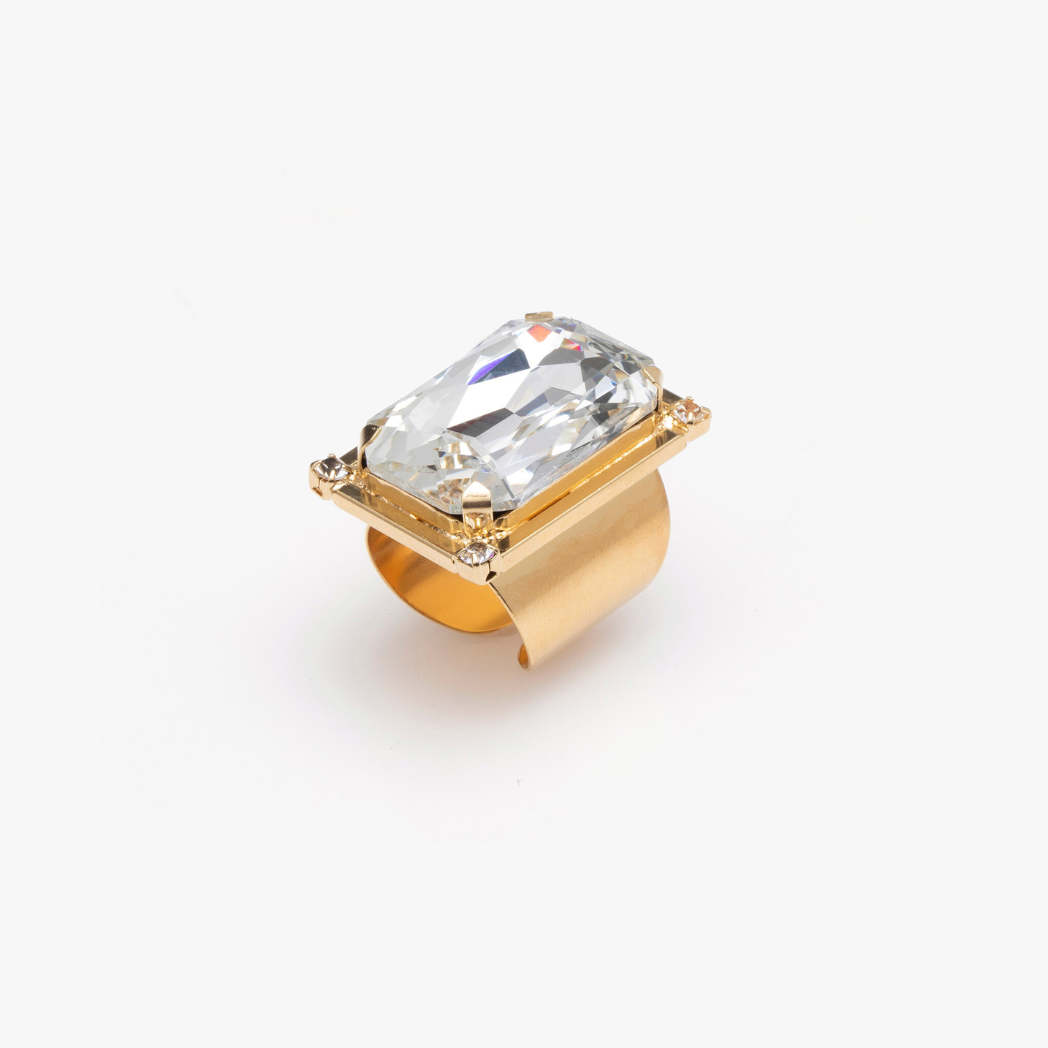 Gold ring with a large clear gemstone on a white background