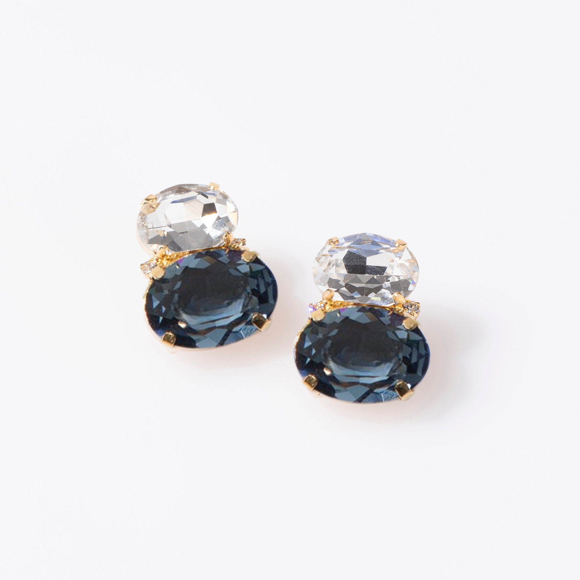 Pair of earrings with blue and clear gemstones on a white background