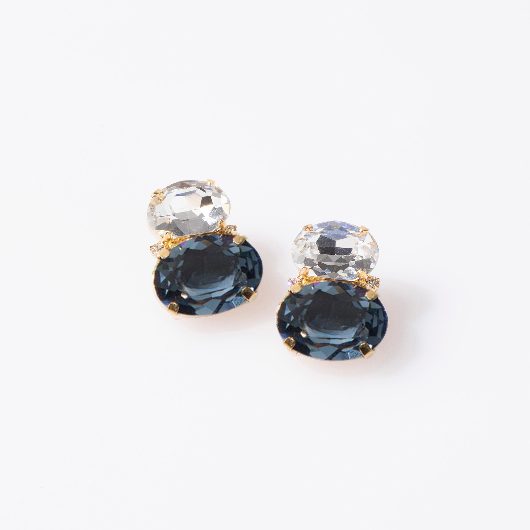 Pair of earrings with blue and clear gemstones on a white background