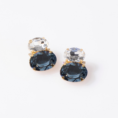 Pair of earrings with blue and clear gemstones on a white background