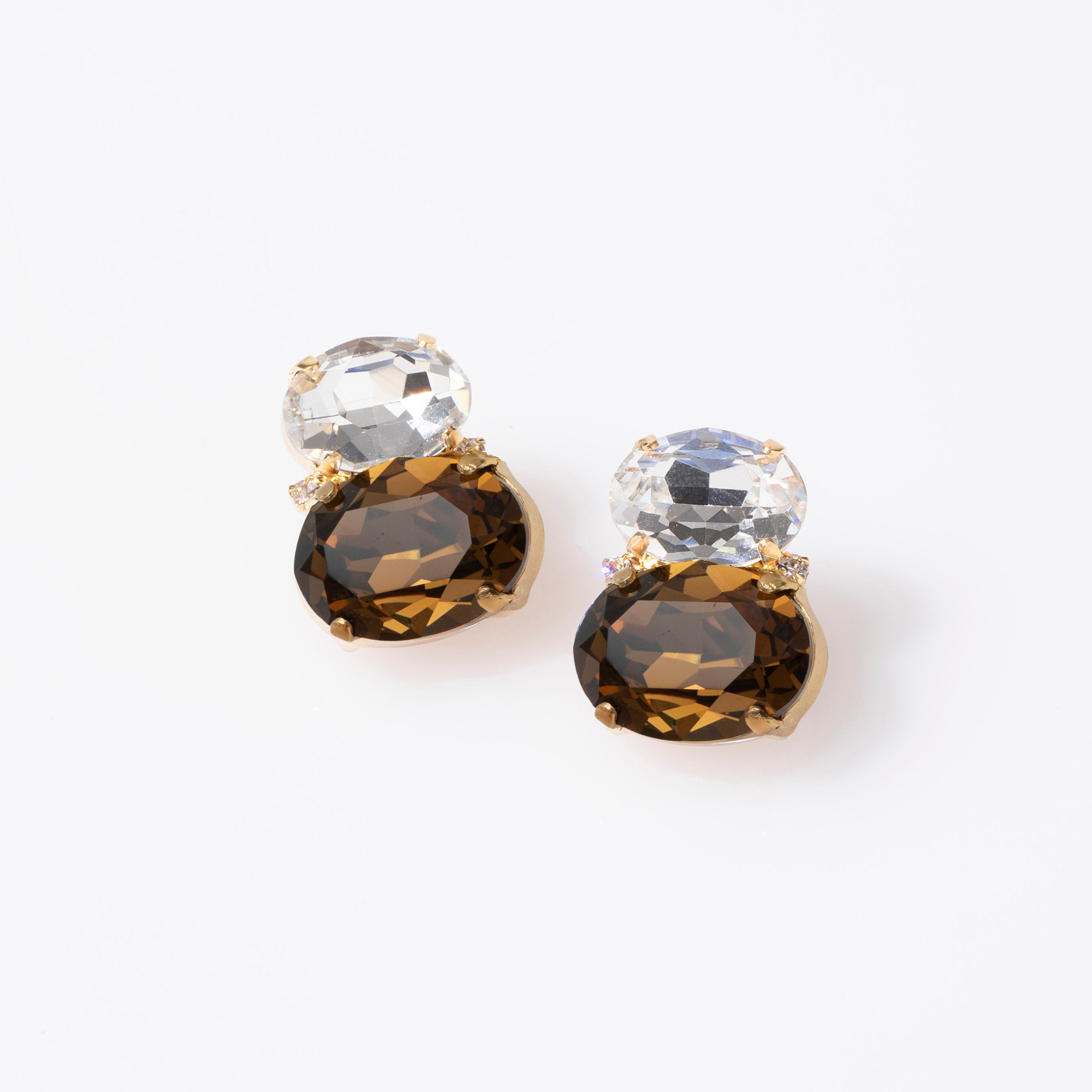Pair of earrings with brown and clear gemstones on a white background