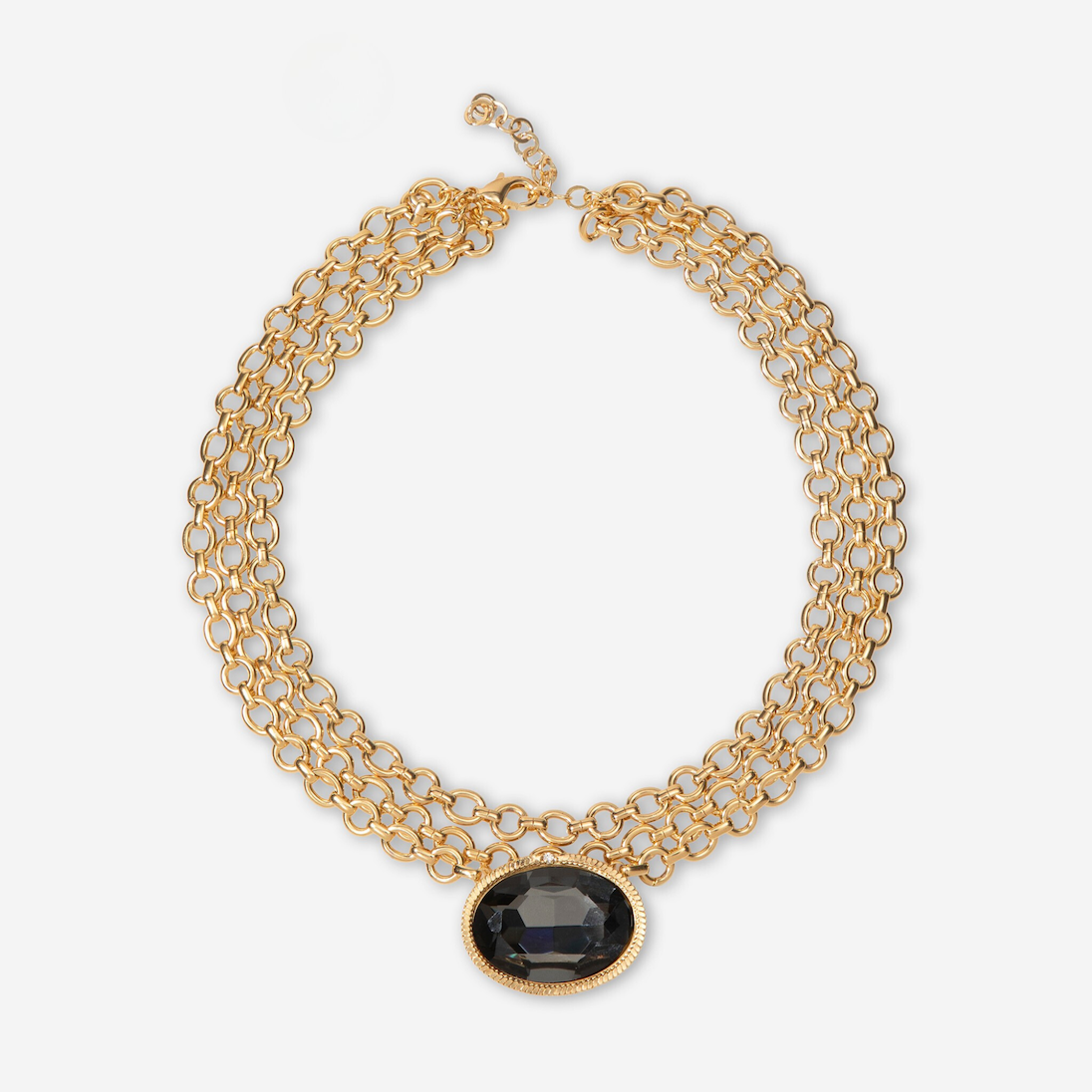 Gold chain necklace with a black gemstone on a white background