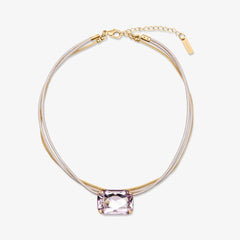 Necklace with a pink gemstone on a white background