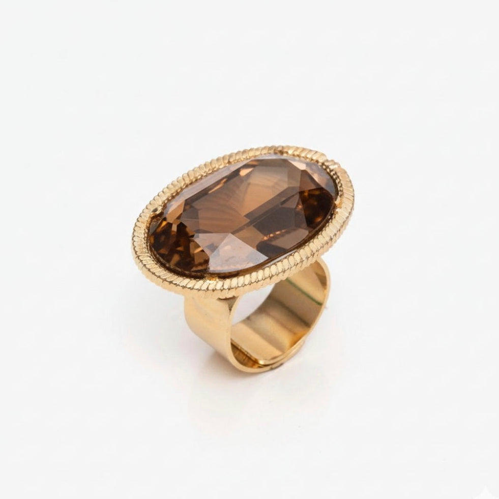 Gold ring with a smoky brown gemstone on a white background