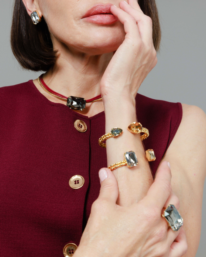 Woman wearing multiple rings on her fingers with a neutral background