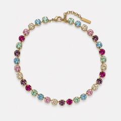 A gold-tone tennis-style bracelet featuring round, colorful gemstones in pink, blue, green, and purple, arranged in a circular shape on a light gray background.