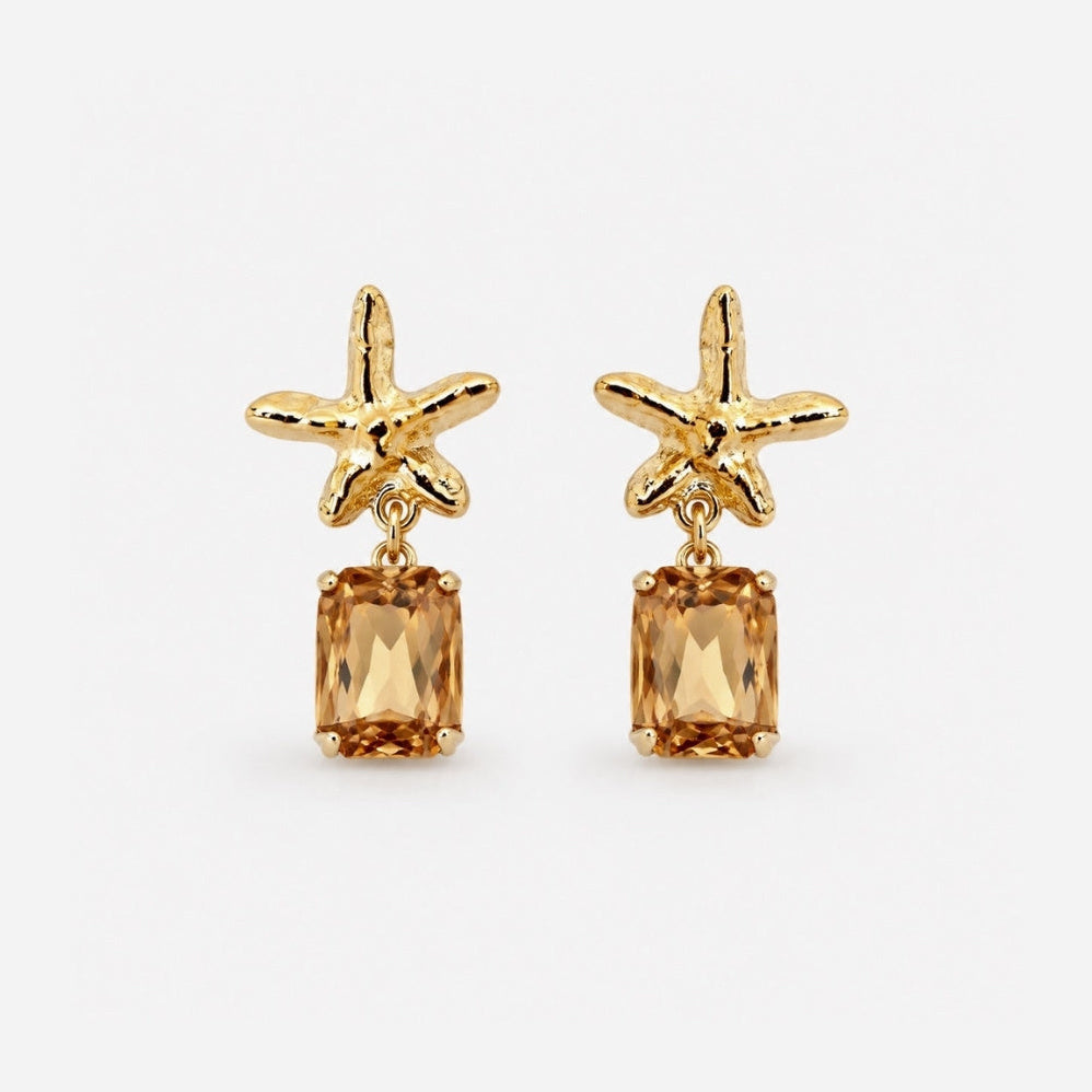 Gold starfish earrings with citrine stones on a white background
