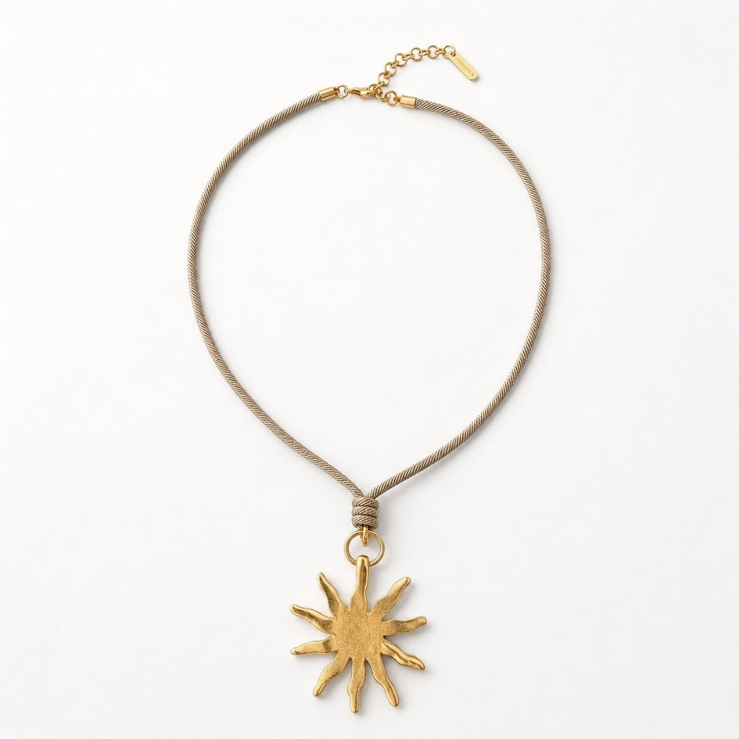 Necklace with a gold sun pendant on a white background