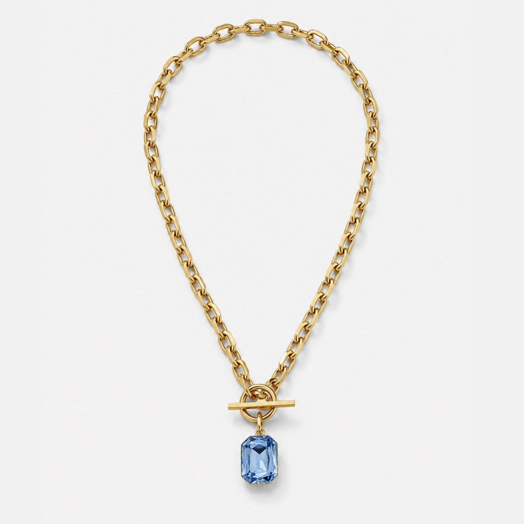 Gold chain necklace with a blue gemstone pendant on a white background