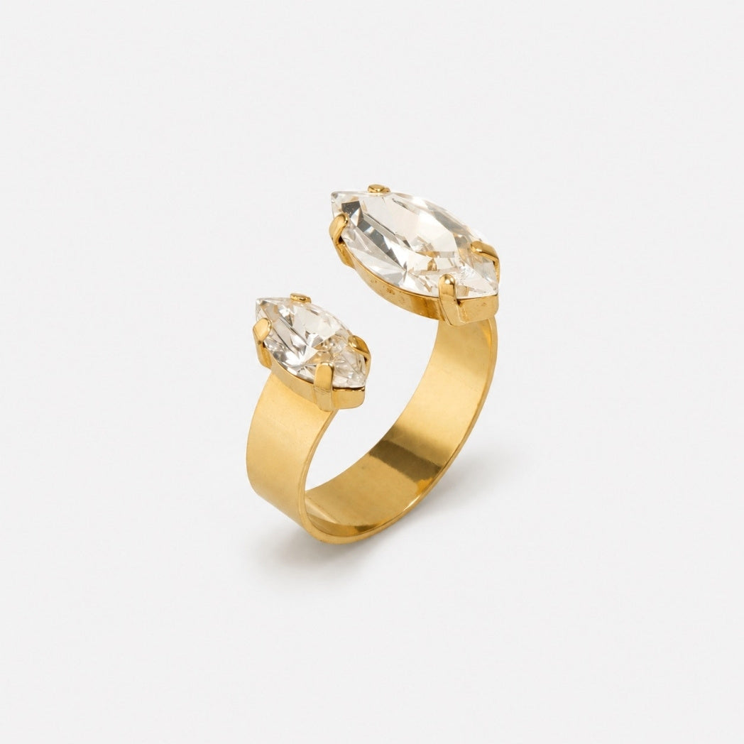 A gold ring with two marquise-cut clear gemstones in a split setting, photographed on a clean white background.