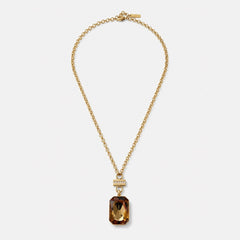 Gold necklace with a brown pendant on a white background