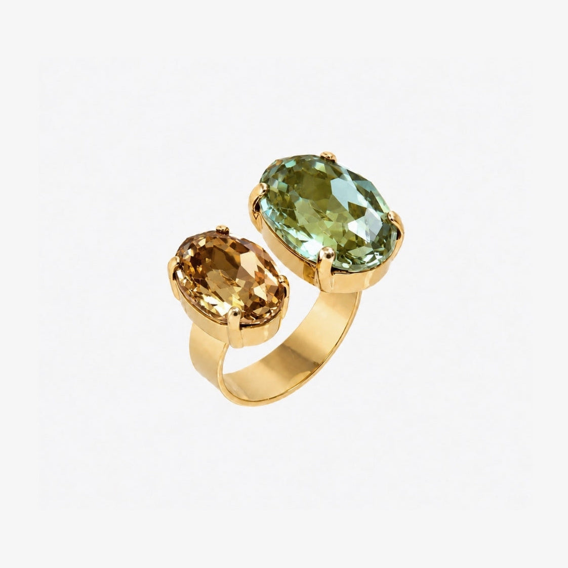 A gold ring featuring two oval-cut gemstones, one light green and one golden yellow, set against a plain white background.
