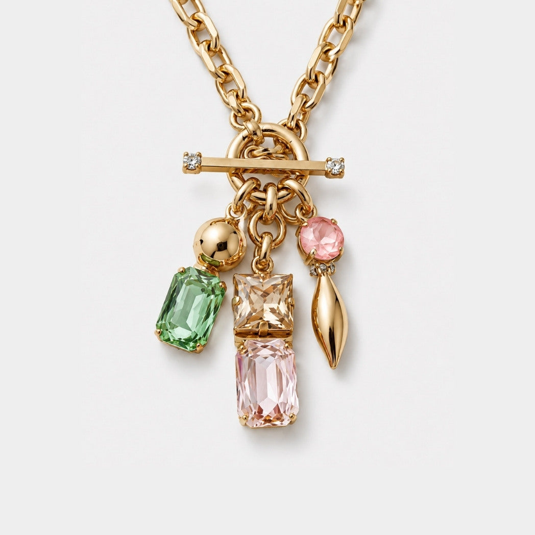 Gold necklace with colorful gemstone pendants on a light gray background
