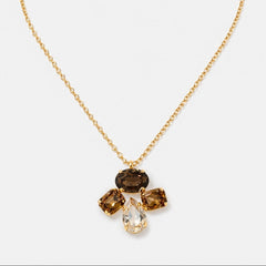 A gold chain necklace with a pendant featuring four gemstones in a flower-like arrangement, including a clear teardrop-shaped stone and three smoky brown rectangular stones, on a light gray background.