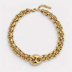 A gold-toned multi-strand chain necklace with a central oval link centerpiece surrounded by small clear stones, photographed on a clean white background.