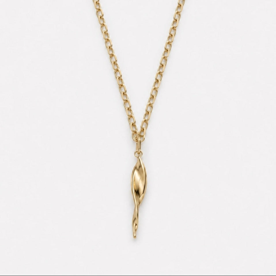 Gold necklace with a unique pendant on a light gray background