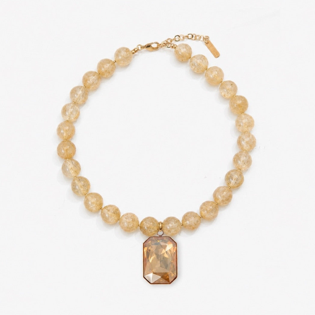Necklace with beige beads and a rectangular pendant on a white background