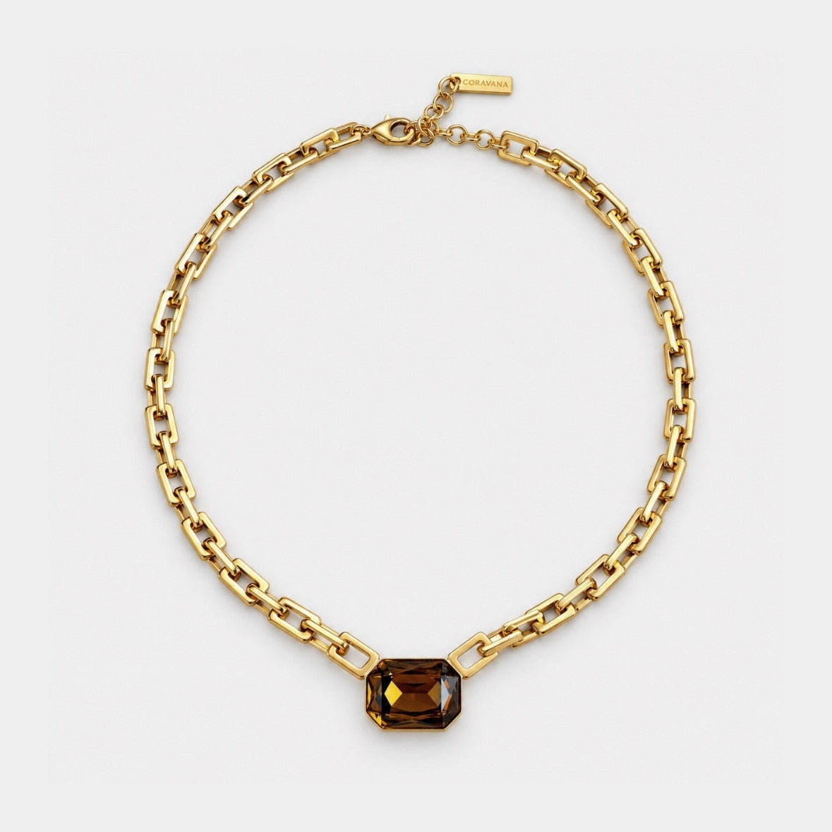 A gold chain necklace with a rectangular faceted brown gemstone pendant, displayed on a clean white background.