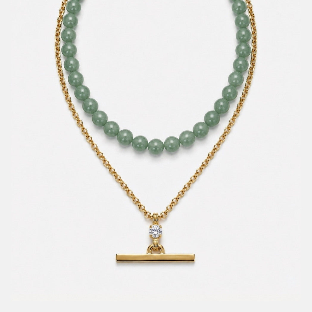 Two necklaces on a white background, one with green beads and the other with a gold clasp.
