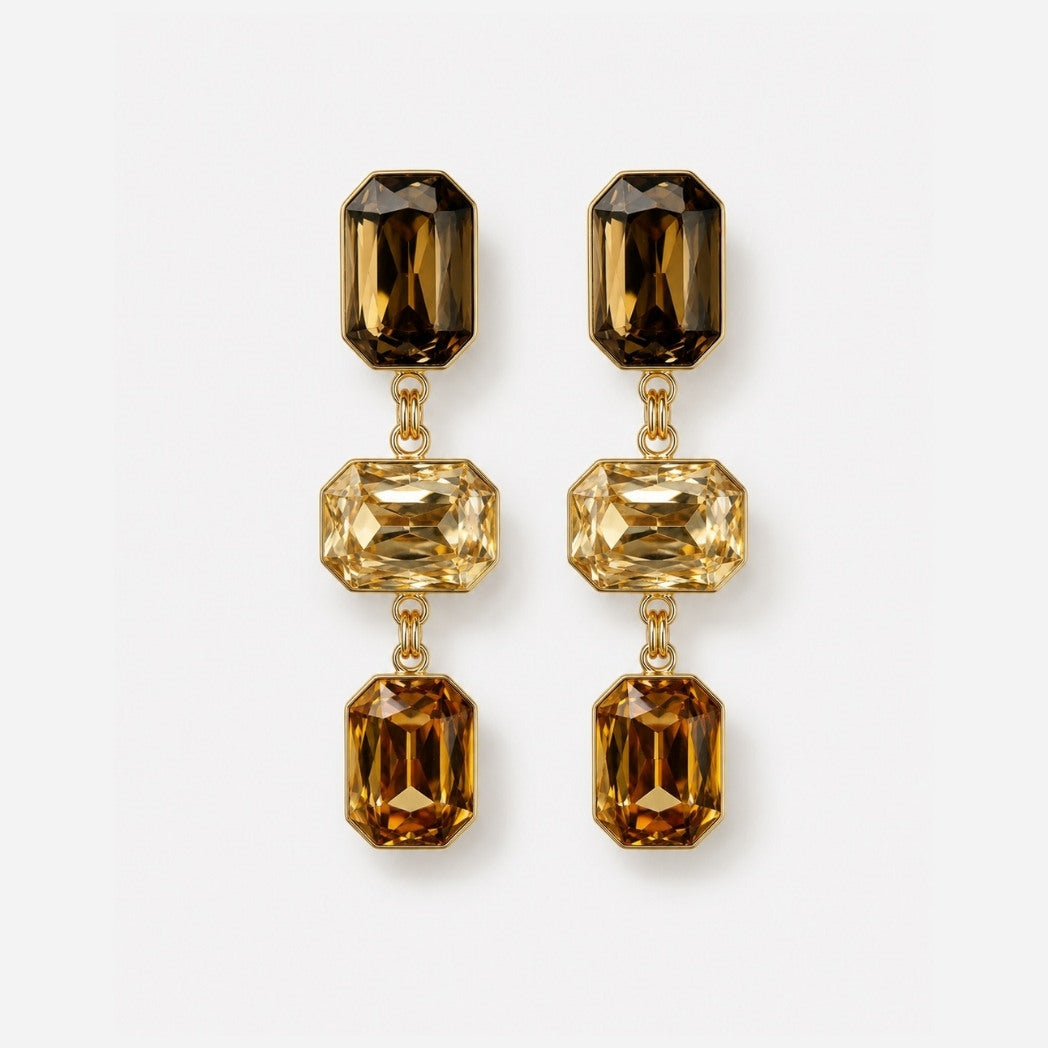Pair of gold earrings with brown gemstones on a white background