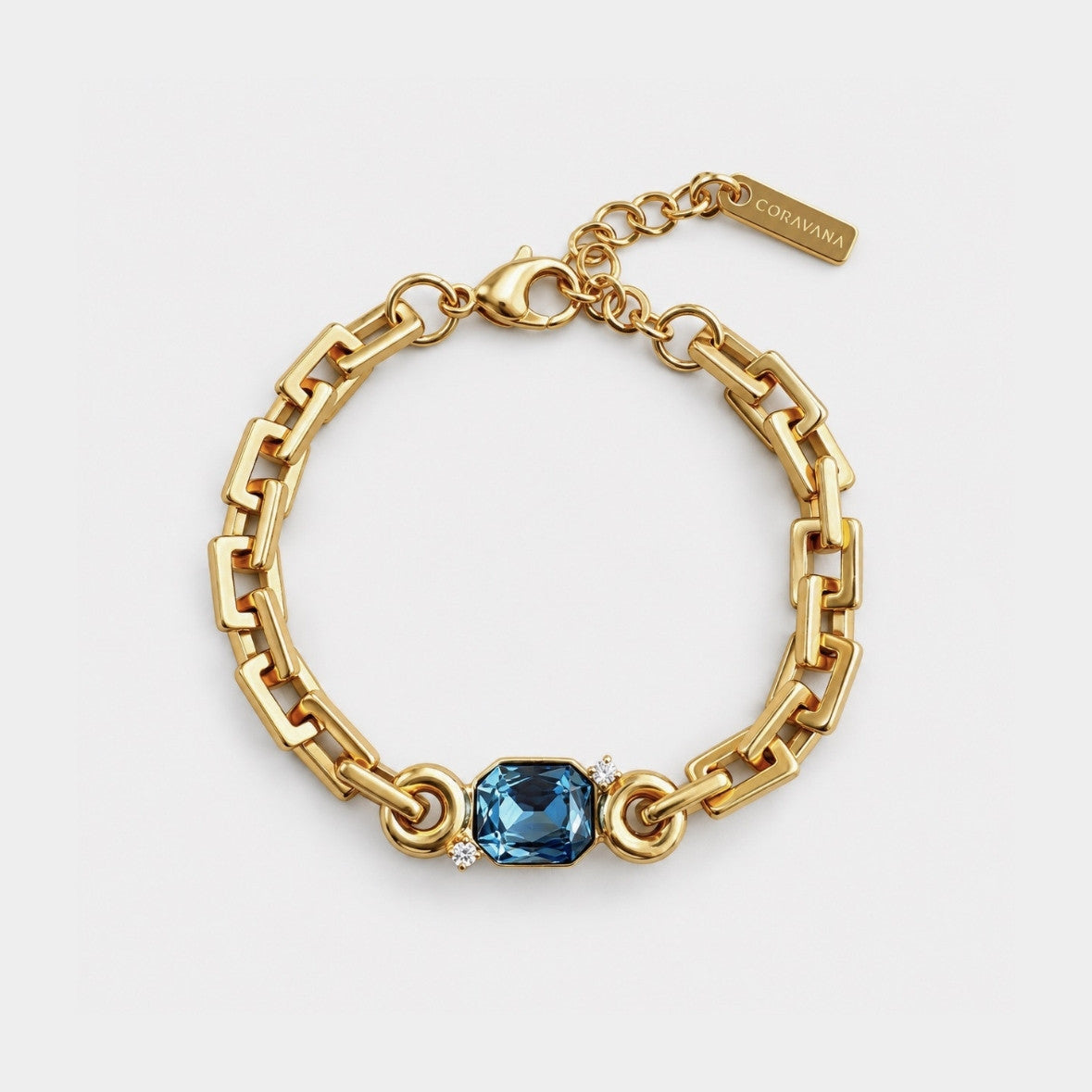 A gold chain bracelet with a central blue gemstone, displayed on a light gray background. The brand name 'SARABINO' is visible on the gold tag attached to the clasp.