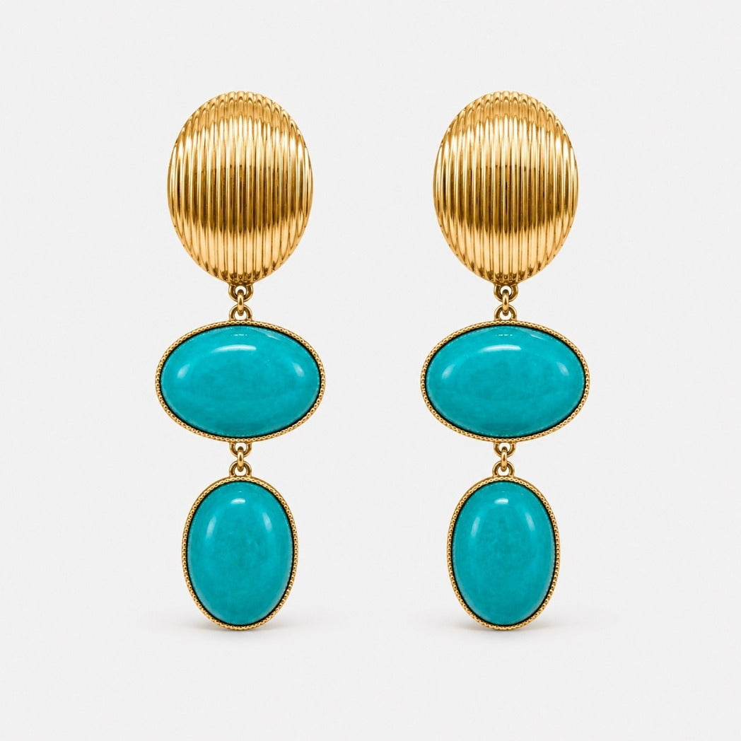 A pair of gold drop earrings featuring a vertically ribbed oval top, a horizontal oval turquoise stone, and a vertical oval turquoise stone, set in gold on a light gray background.