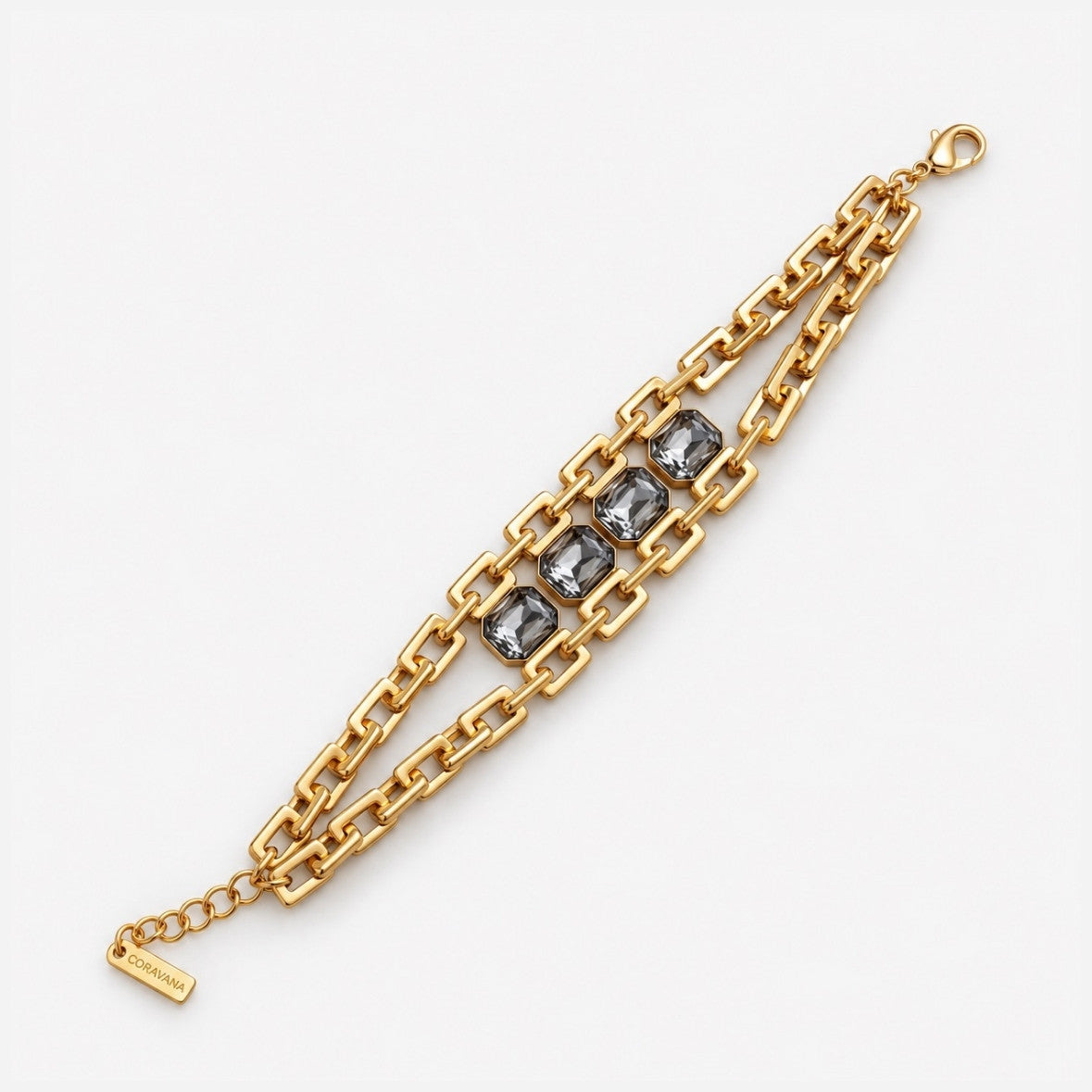 A gold-toned chain bracelet featuring three rectangular gray gemstones in the center, displayed on a clean white background.