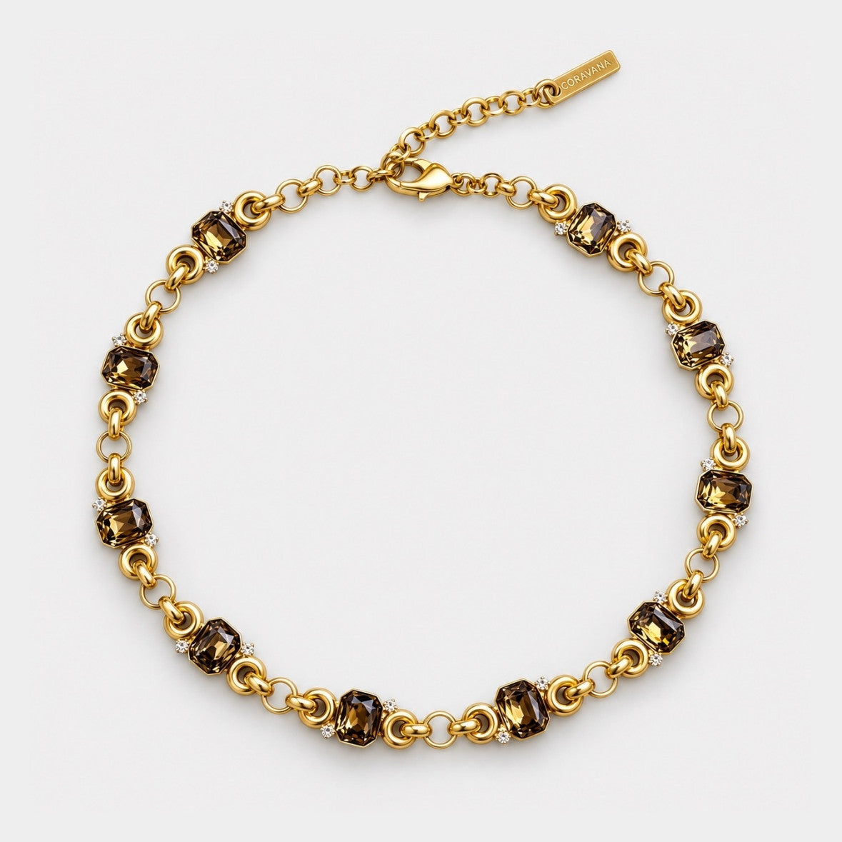 A gold chain bracelet with alternating dark brown faceted gemstone links and small clear crystal accents, displayed on a clean white background.