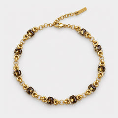 A gold chain bracelet with alternating dark brown faceted gemstone links and small clear crystal accents, displayed on a clean white background.