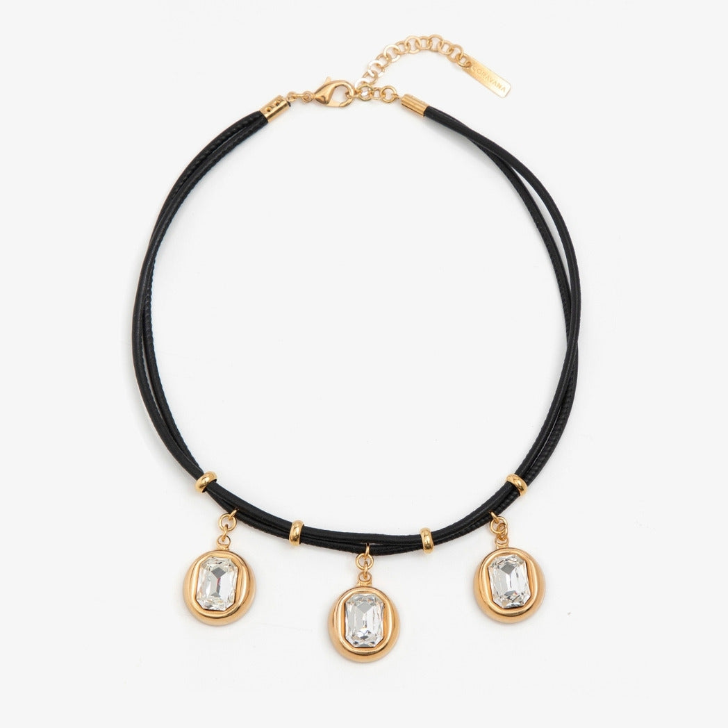 Necklace with black cord, gold accents, and crystal pendants on a white background