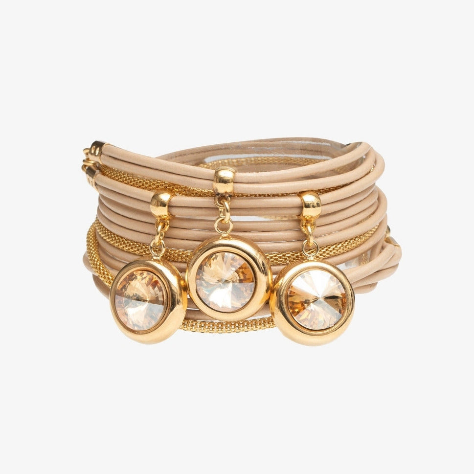 Stack of gold bracelets with crystal embellishments on a white background
