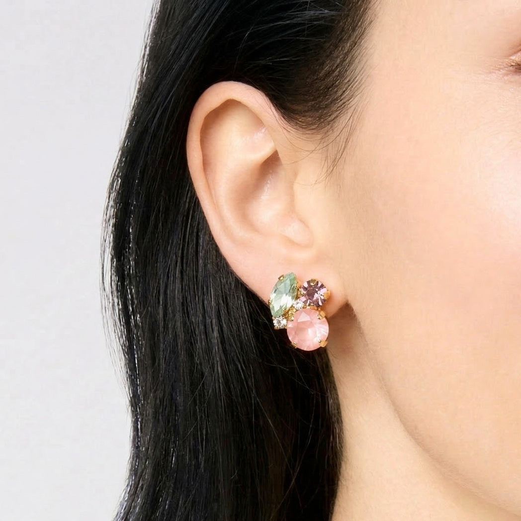 Close-up of an ear wearing a colorful earring against a neutral background