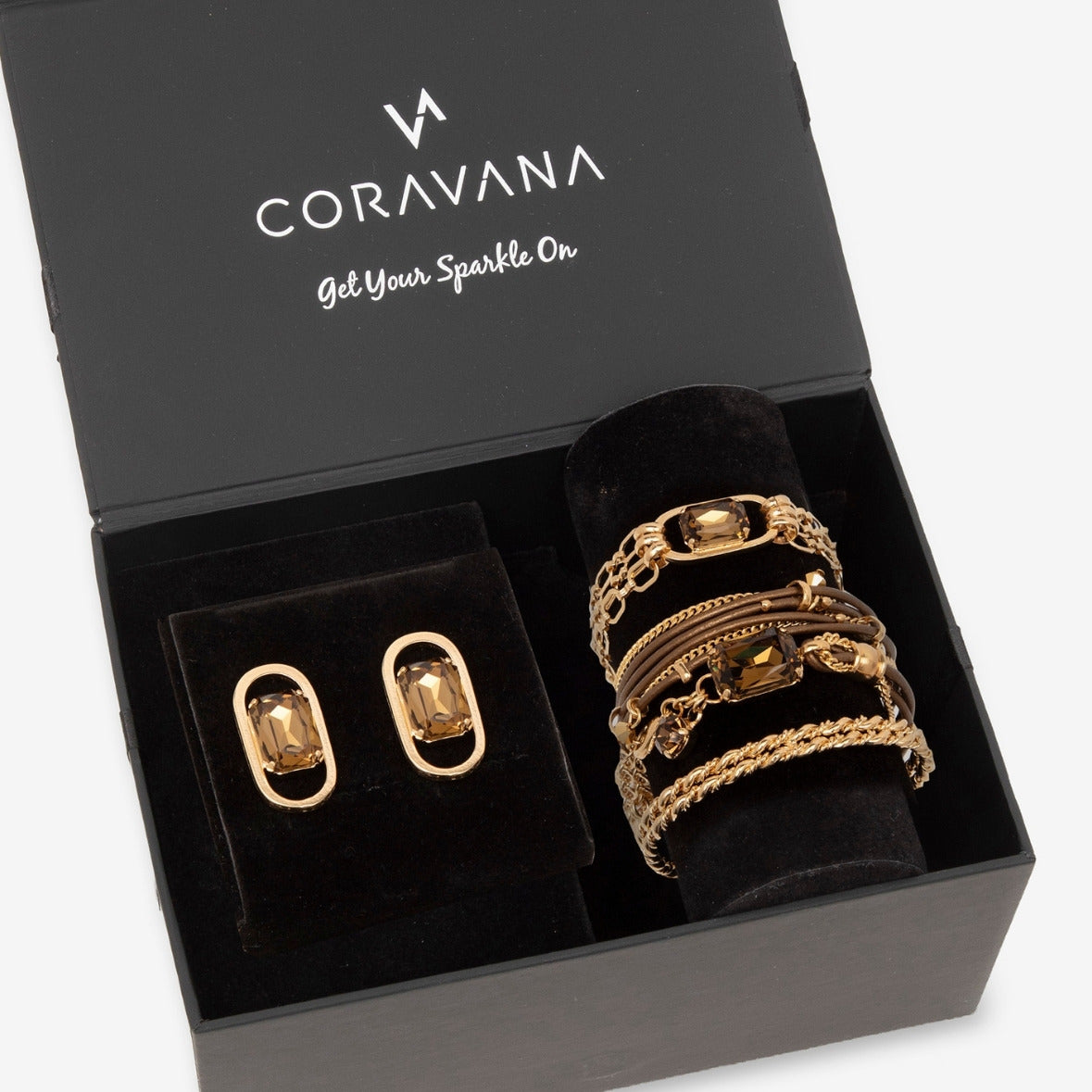 Gold jewelry set including rings and earrings in a Coravana box.