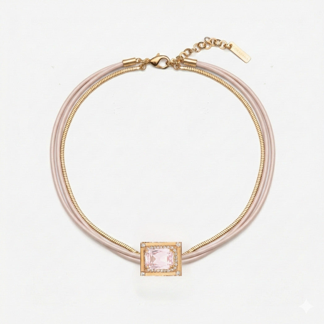 Necklace with pink gemstone and gold accents on a light gray background