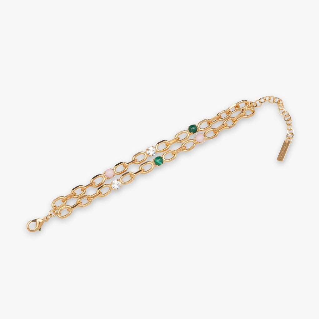 Gold chain bracelet with green and clear gemstones on a white background