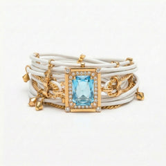 Stack of bracelets with a blue gemstone and gold accents on a white background