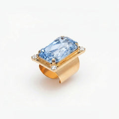 Gold ring with a blue gemstone on a white background