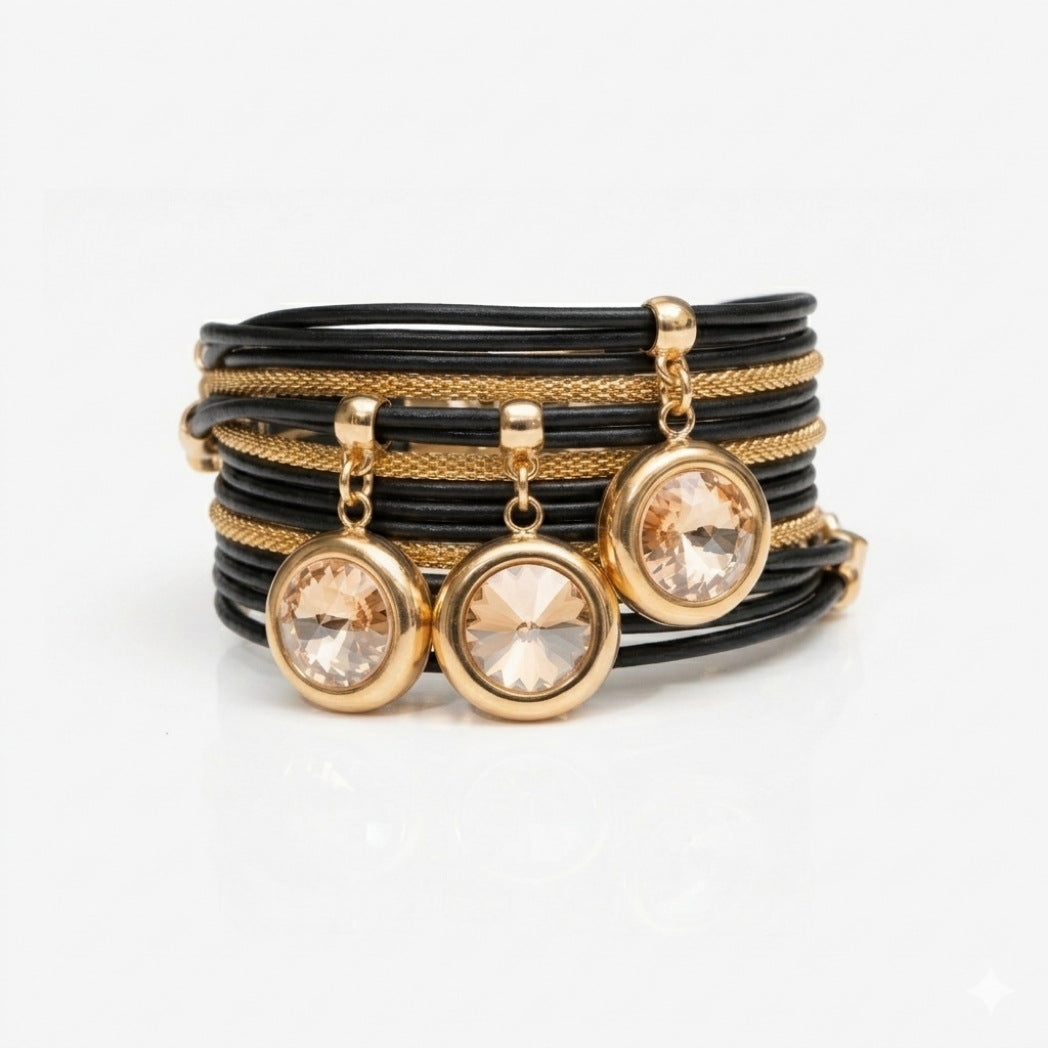 Set of black and gold bracelets with crystal charms on a white background