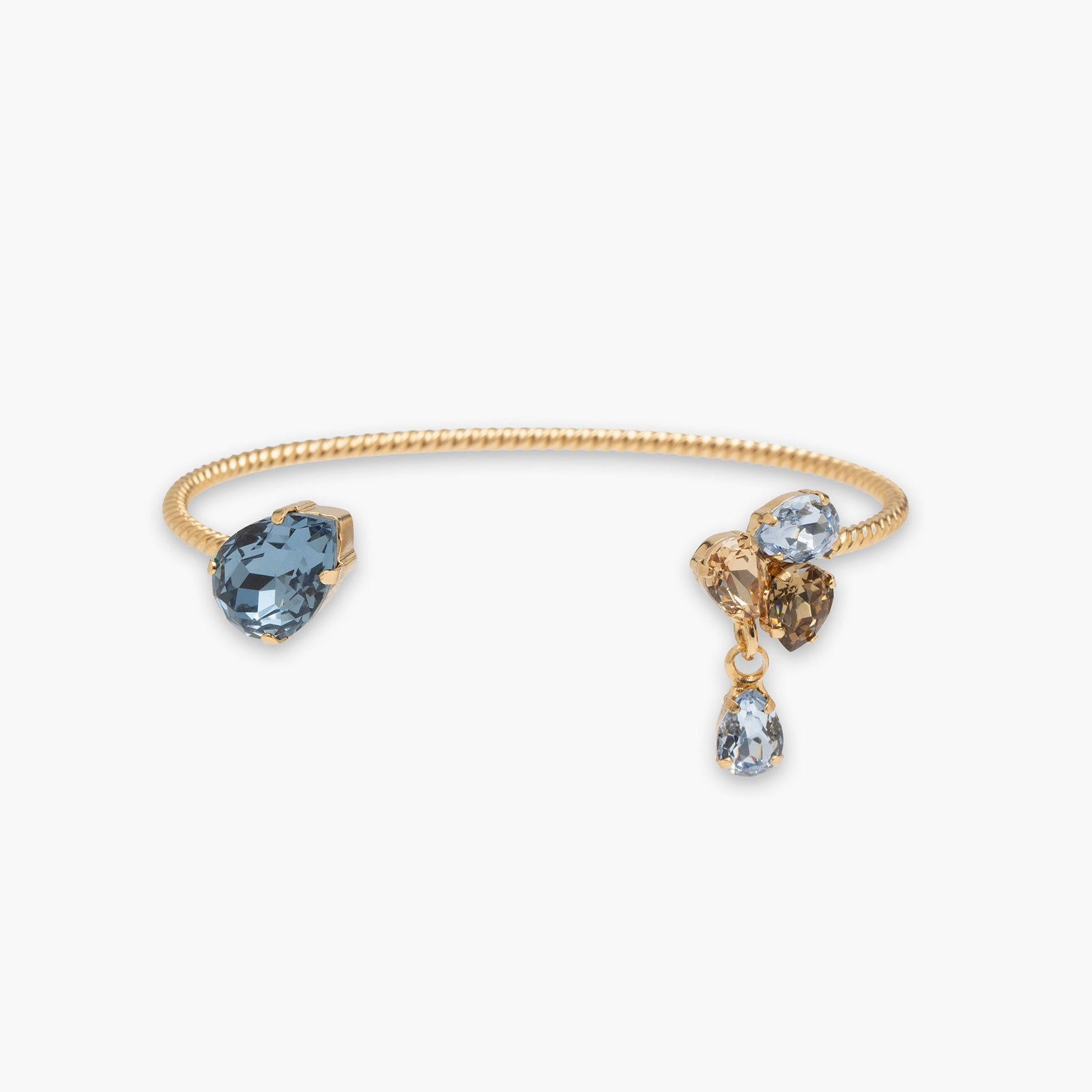 Gold bracelet with blue, brown, and clear gemstones on a white background