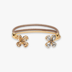Gold hair tie with flower-shaped ends on a white background
