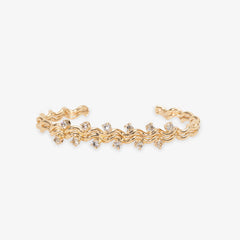 Gold bracelet with small crystals on a white background